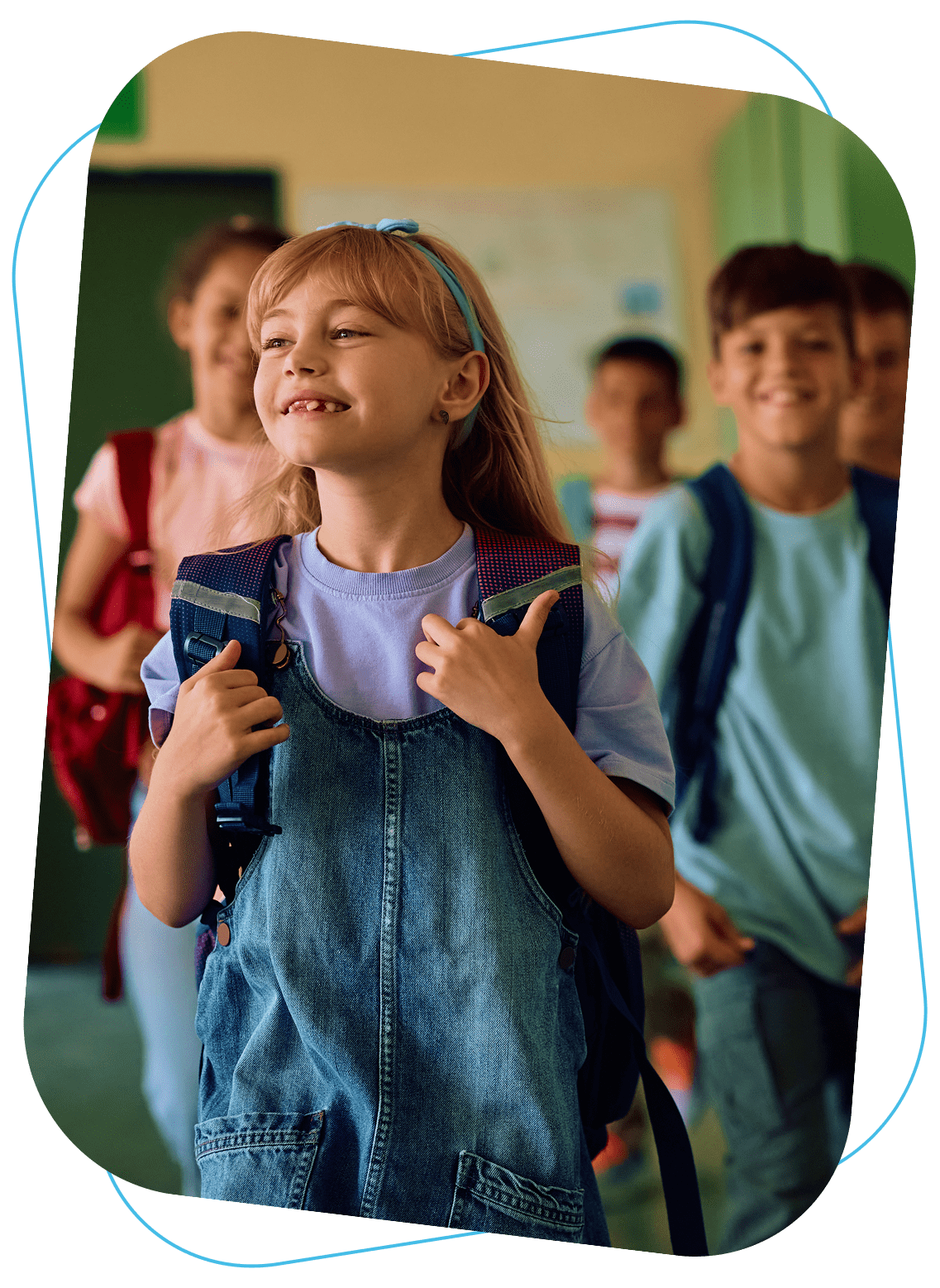 Happy children carrying backpacks in a school hallway.
