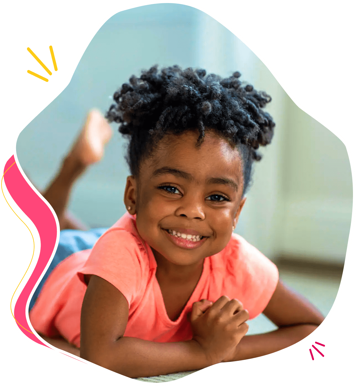 A smiling child lying down with a raised arm.