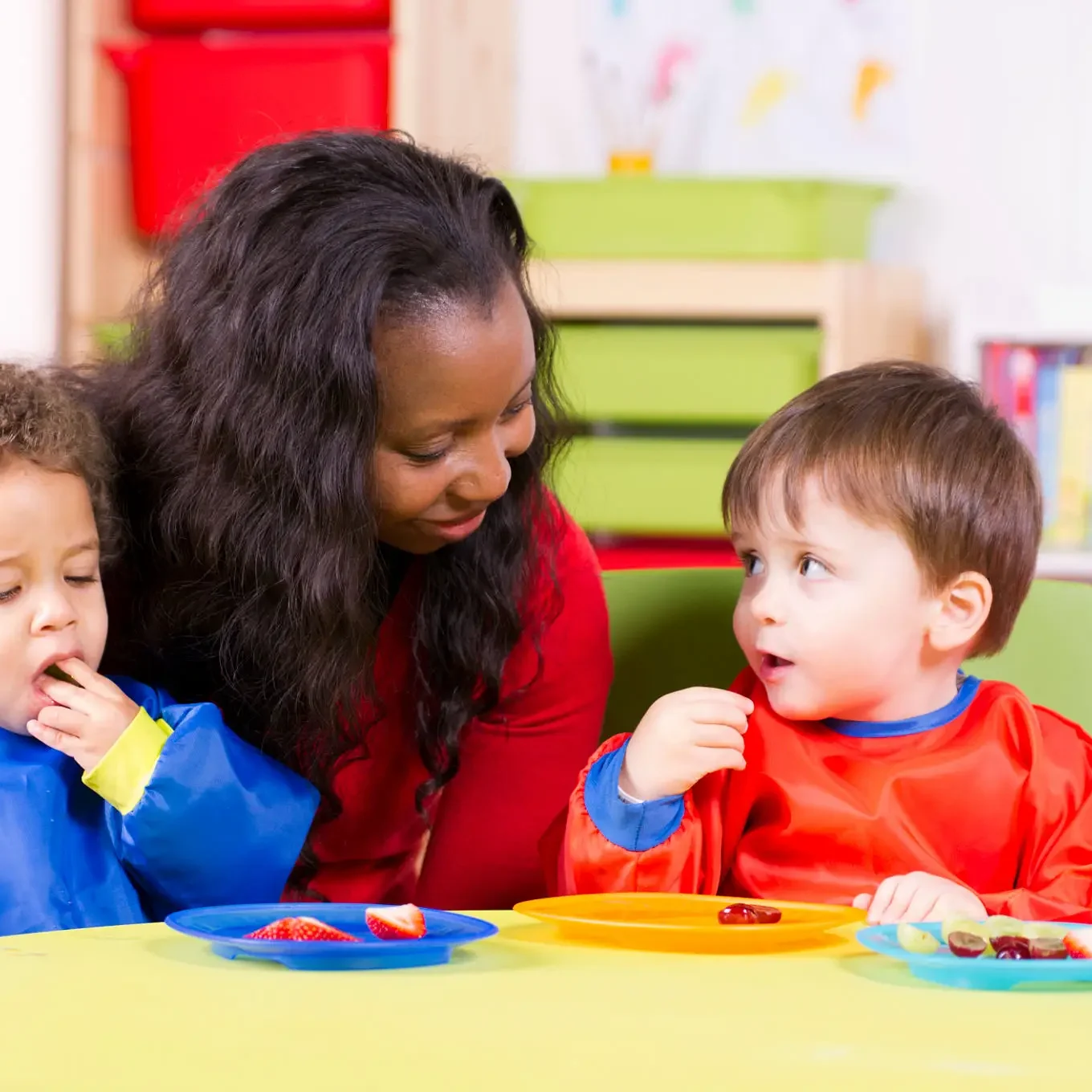 A woman and two children eating at a table.